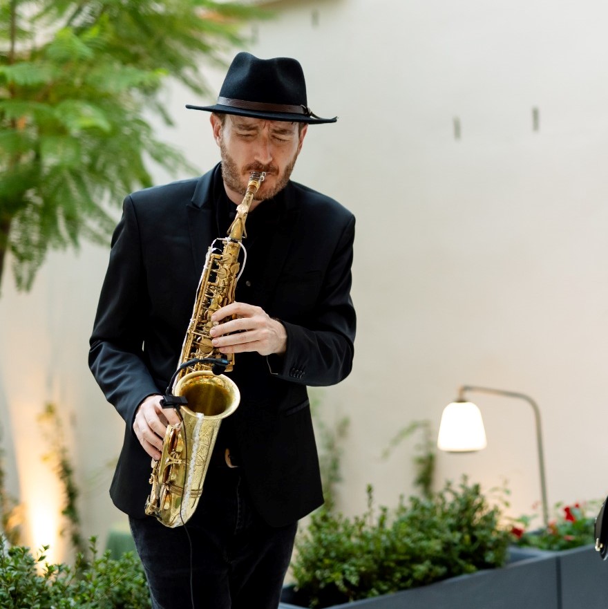 Saxofonista femenina interpretando música en vivo durante un evento en Barcelona, contrataciones con Saulė Espectáculos.